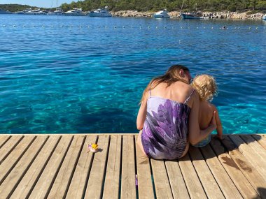 Annem ve babam tahta zeminde oturuyorlar.