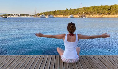 Sahilde duran manzaralı kadın. 