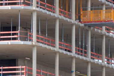 Şehir gelişimi ve fütüristik mimari olarak betondan yapılmış yeni bir modern binaya sahip inşaat alanı, ağır vinçleri ve makineleri olan mühendisler ve sanayi işçilerinin işyeri.