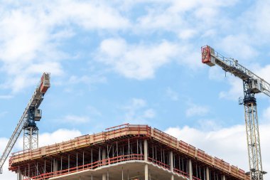 Bulutlu bir günde bina inşaatında vinç