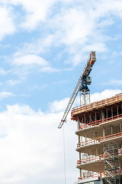 Bulutlu bir günde bina inşaatında vinç