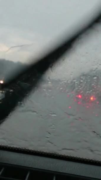 내리는 곳에서 자동차가 바람막이 유리를 지나가는 빗방울 자동차가 지나가는 날씨때문에 — 비디오