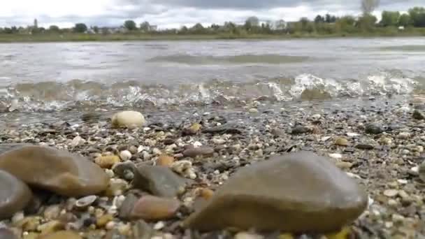 平静流淌的河水冲击着河岸的岩石 河水清澈晶莹 海浪小 地面上反射出健康的环境和健康的生态系统 — 图库视频影像