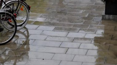Yağmurlu bir sonbahar ve sonbaharda yağmurlu bir günde yağmur damlalarıyla yağmur damlaları yağması, yağmur mevsiminde sıfır emisyonla motosikletçiler ve bisiklet meraklıları için yeşil hareketliliğin zorlu tarafını gösteriyor.