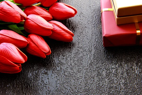 Gifts and flowers on a black background. Gift box.