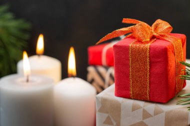 Mumlu Noel hediyesi kutusu. Noel hediyeleri kırmızı, beyaz kutular siyah ve mavi arka planda. Fotokopi alanı olan düz bir yer. Yakın çekim hediyeleri.