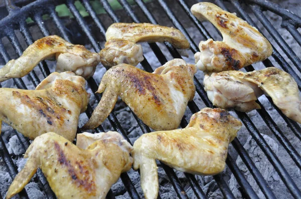 Grilling spicy chicken wings on barbecue grill..