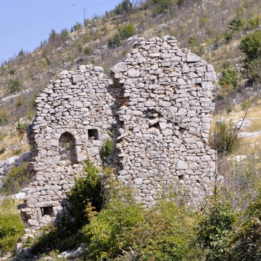 Mavi gökyüzüne karşı eski bir evin kalıntıları .