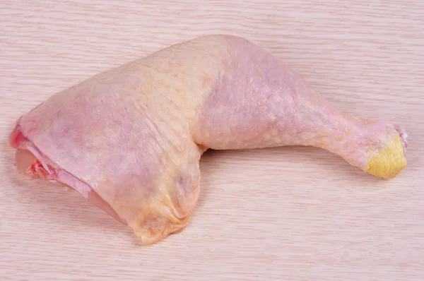 Cuisses de poulet crues avec peau couchée sur une planche à découper en bois. Haut — Photo