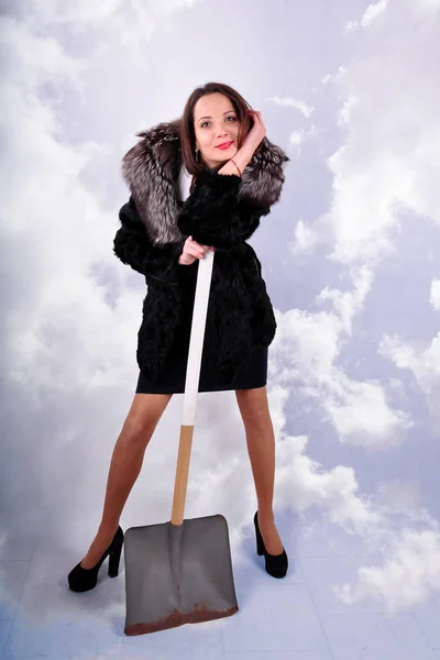 Extravagant woman in a half hem with a shovel for snow removal o — Stock Photo, Image