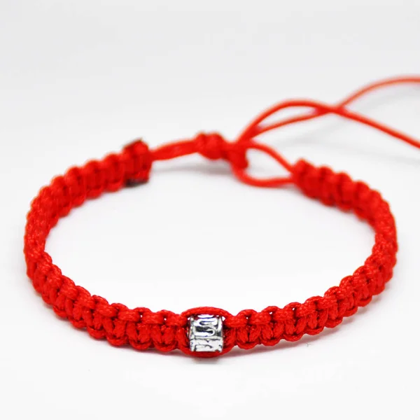 Delicate decorative bracelet woven from red rope. — Stock Photo, Image