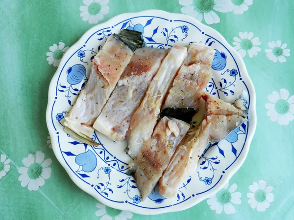 daha fazla hazırlık için tabakta pişirilen taze kesilmiş balık.