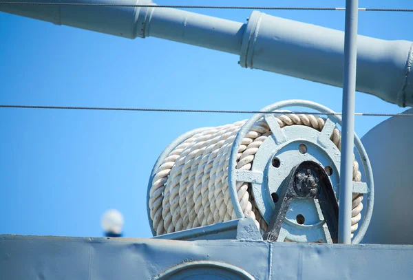 Mavi gökyüzüne karşı geminin güvertesinde bir halatla kablo makarası
