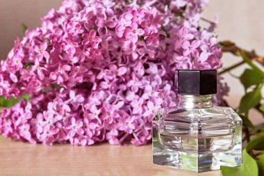 Parfüm şişesi ve leylak çiçekleri. Feminite kavramı