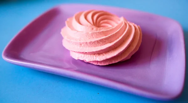 Gâteau meringue rose sur une assiette violette — Photo