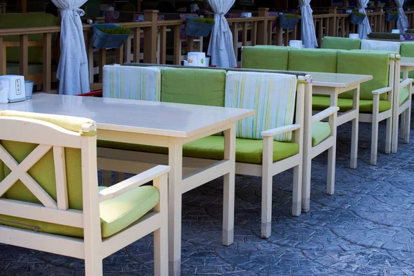 Terraza veranda de verano de un café. Acogedoras sillas y mesas de madera verde —  Fotos de Stock