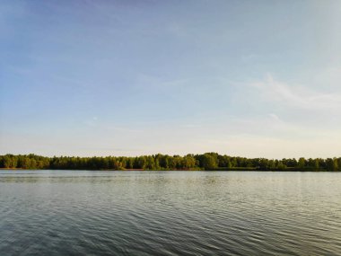 Gökyüzü, bulutlar ve su ile bir yaz akşamı küçük bir gölet peyzaj fotoğrafı