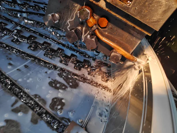 Фотография процесса резки металла крупным планом на запрограммированной машине с сильным потоком охладителя — стоковое фото