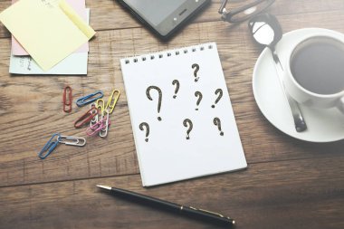 Soru işaretleri üstünde beyaz bir defter
