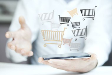 adam alışveriş sepetlerini gri arka plan üzerinde ile telefon ile