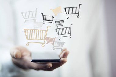adam alışveriş sepetlerini gri arka plan üzerinde ile telefon ile
