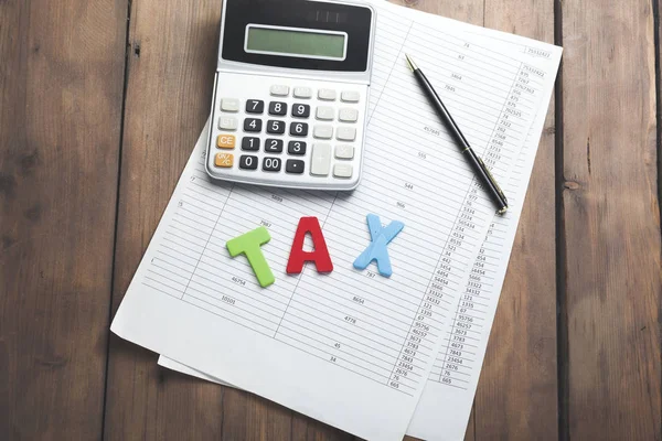 Hesap makinesi, closeup makaleler ve vergi tablo üzerinde kelime
