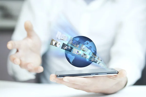 Businessman holding  phone with globe above.Technology concept