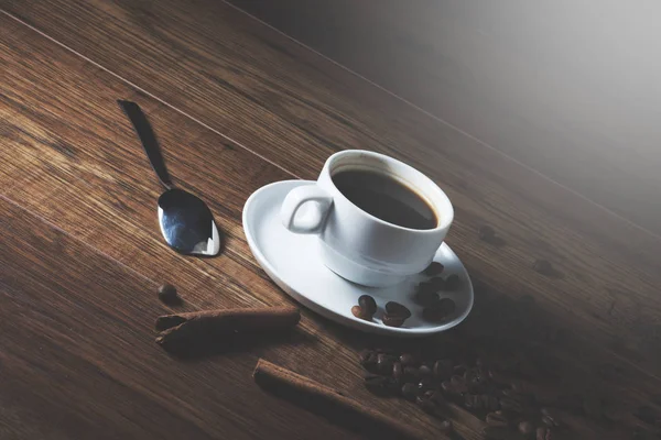 Tahta masada bir fincan kahve ve tarçın.