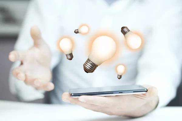 businessman  holding phone with  light bulbs above