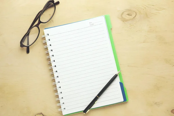 ノートと眼鏡と木製の背景の上にペン — ストック写真