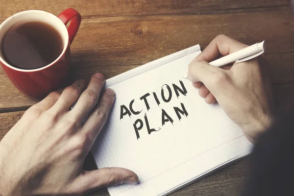 Man Skriver Action Plan Text Anteckningsboken Med Kaffe Skrivbord — Stockfoto
