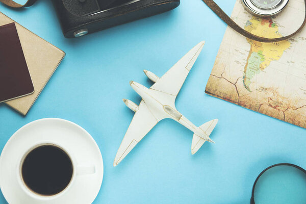 Different travel accessories and coffee on blue background