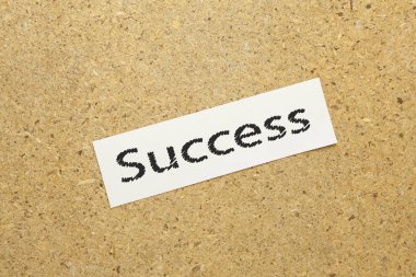 Kağıt üzerinde kahverengi zemin üzerinde yazılı başarı metin