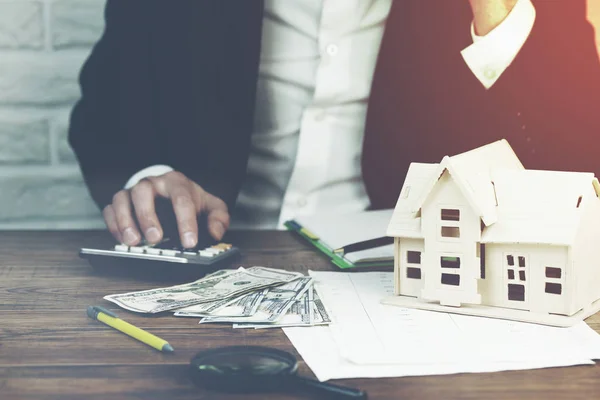 hesap makinesi ev modeli ve tablo üzerinde para el