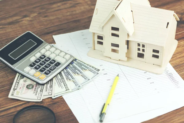 house model,calculator and money on documents on table