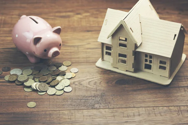 Ev ve kumbara para yığınları üzerinde küçük modeli