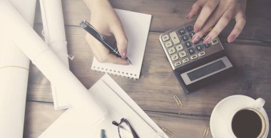 kadın el hesap makinesi ve çalışma masası üzerinde kalem