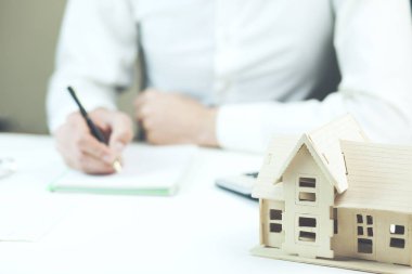 Erkek el Not Defteri'nde tablo ile ev modeli üzerinde yazma 