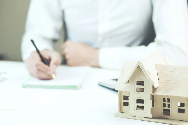 Manos Masculinas Escribiendo Bloc Notas Sobre Mesa Con Modelo Casa —  Fotos de Stock