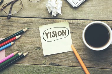 Vizyon metin üzerinde ahşap masa üstünde not etmek 