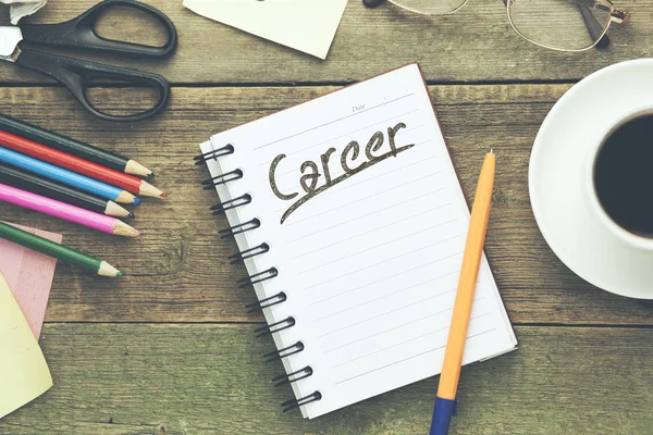 career text written on  notepad with stationary on table
