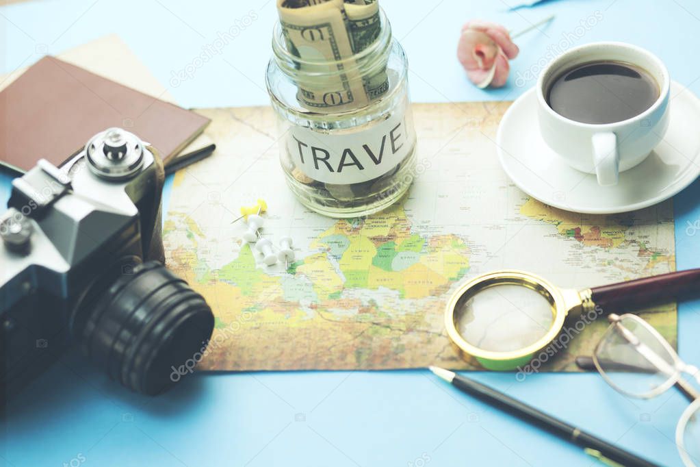 saving money for travel.  different travel items on table  