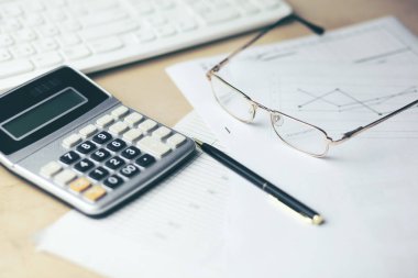 belgeler ve ofis masası üstünde klavye ile hesap makinesi  