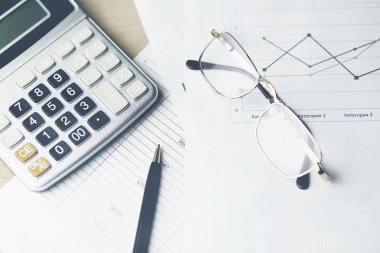belgeler ve ofis masası üstünde klavye ile hesap makinesi  