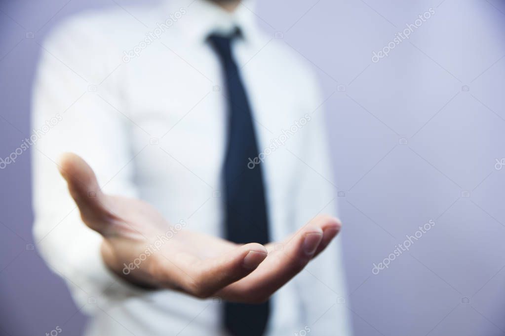 Businessman with empty hand on gray background