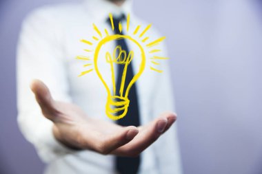 ampul simgesi üzerinde el ile iş adamı