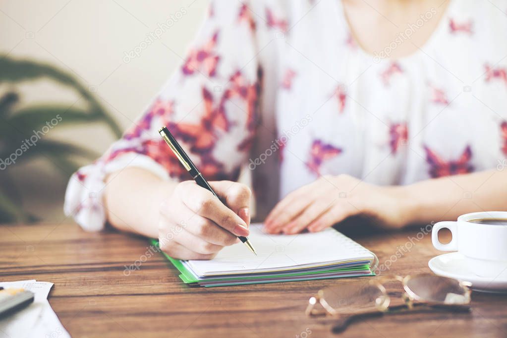 woman with  notepad and cup of coffee
