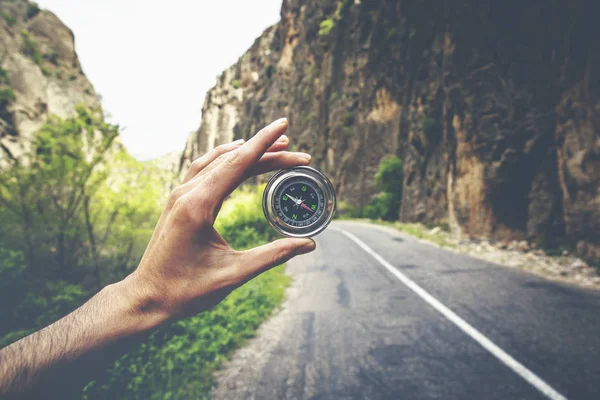 道路景観上磁気コンパスを保持している人の手 — ストック写真