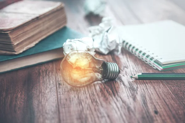 idea light bulb with  books on table