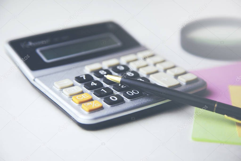 different  stationery on table. Calculator and pen 